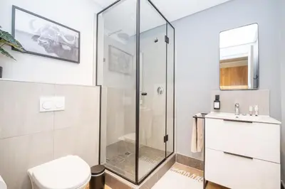 a bathroom with a glass shower stall and a toilet at 705 Riverlands - 1Bedroom Apartment with Mountain Views in Cape Town