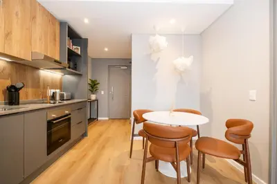 a kitchen and dining room with a table and chairs at 705 Riverlands - 1Bedroom Apartment with Mountain Views in Cape Town