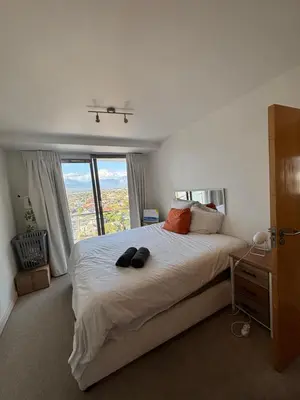 a bedroom with a large bed with a large window at A little heaven in Strand