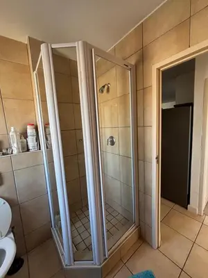 a shower with glass doors in a bathroom at A little heaven in Strand