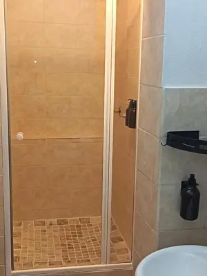 a shower with a glass door in a bathroom at Danlavie in Tyger Valley