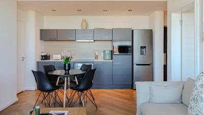 a kitchen with a table and chairs in a living room at Bridgewater Serenity Collection 708 in Cape Town