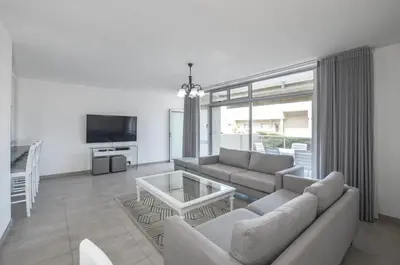 a living room with a couch and a table at 2 Bedroom Apartment - Dolphin Beach in Cape Town