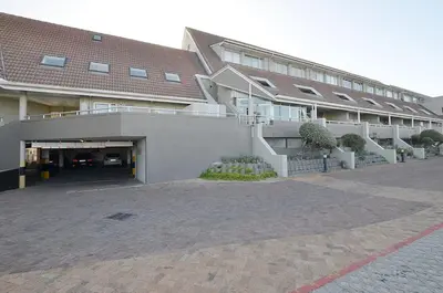 a building with a parking lot in front of it at 2 Bedroom Apartment - Dolphin Beach in Cape Town