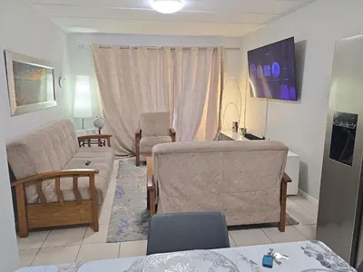 a living room with a couch and a table at Blouberg 2 bedroom apartment in Cape Town