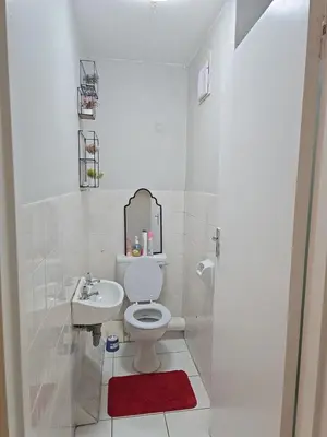 a white bathroom with a toilet and a sink at Blouberg 2 bedroom apartment in Cape Town