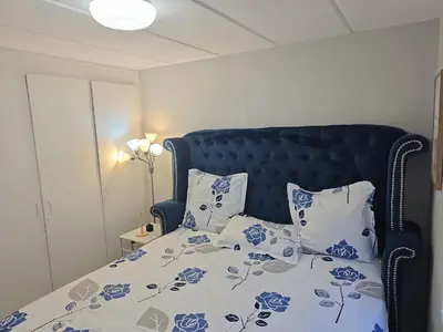 a bed with blue and white sheets and pillows at Blouberg 2 bedroom apartment in Cape Town