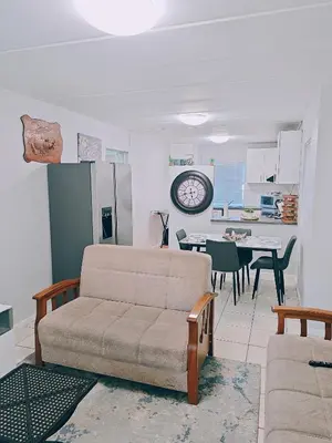 a living room with a couch and a kitchen at Blouberg 2 bedroom apartment in Cape Town
