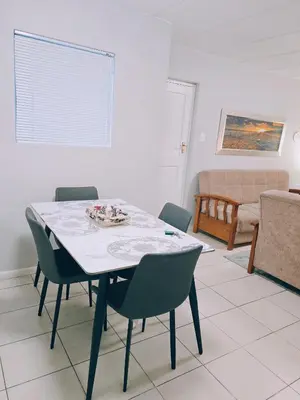 a dining room with a table and chairs at Blouberg 2 bedroom apartment in Cape Town