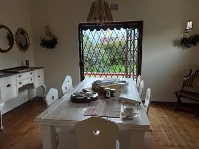a dining room with a table and chairs and a window at Hermanus Hartshuis in Hermanus