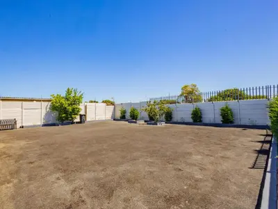 a large yard with a fence in the background at Olive Grove Bed & Breakfast in Kraaifontein