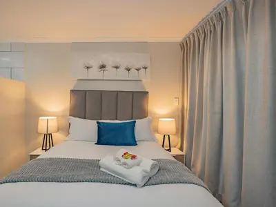 a bedroom with a bed with towels on it at Olive Grove Bed & Breakfast in Kraaifontein