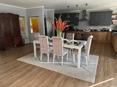 a kitchen and dining room with a white table and chairs at 10onErika Franschhoek in Franschhoek