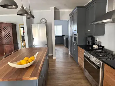 a kitchen with a bowl of fruit on a wooden counter at 10onErika Franschhoek in Franschhoek
