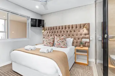 a bedroom with a large bed with towels on it at Lagoon Beach Luxe 116A in Cape Town