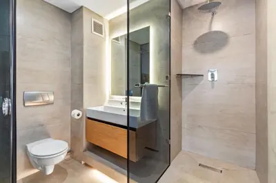 a bathroom with a toilet and a sink and a shower at Lagoon Beach Luxe 116A in Cape Town