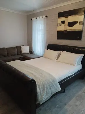 a bedroom with a large bed and a couch at Heaven Scent in Bettyʼs Bay