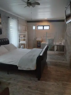 a bedroom with a large bed with a ceiling fan at Heaven Scent in Bettyʼs Bay
