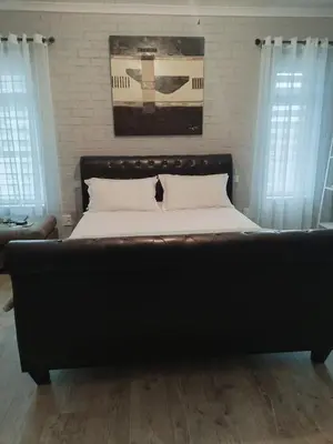 a large bed in a bedroom with white walls at Heaven Scent in Bettyʼs Bay