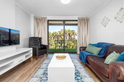 a living room with a couch and a tv at La Savina The Island Club in Cape Town