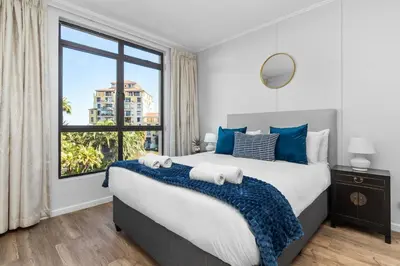 a bedroom with a large bed with a large window at La Savina The Island Club in Cape Town