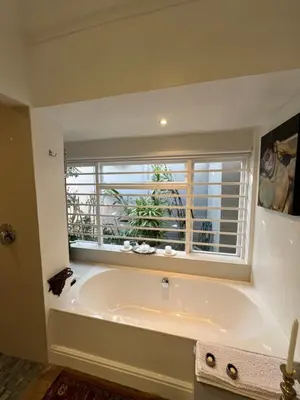 a large bath tub in a room with a window at Somerset West All Stay 4 in Somerset West