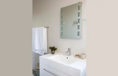 a white bathroom with a sink and a mirror at 43 On Sandstone in Somerset West