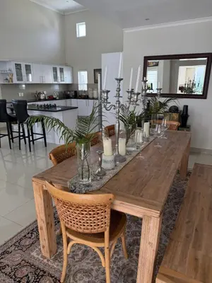 a wooden table with chairs and candles on it at Parklands Family Stay in Cape Town