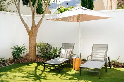 two chairs and an umbrella in a yard at Luxury Villa in Best Central Location in Franschhoek