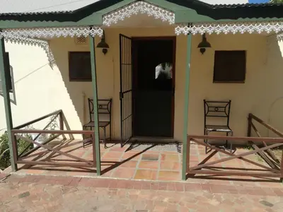 a front porch of a house with two chairs at House On Plein in Paarl