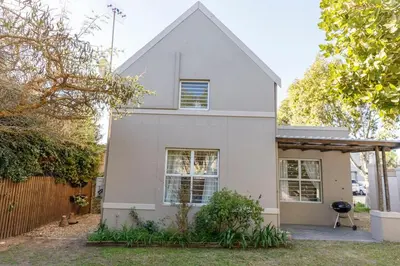 a white house with a fence at Home in Durbanville in Oakdale