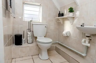 a bathroom with a toilet and a sink at Home in Durbanville in Oakdale