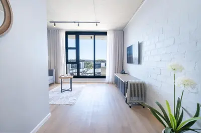 a living room with a radiator and a white brick wall at 413 Riverlands - 1 Bedroom Apartment with Parking in Cape Town