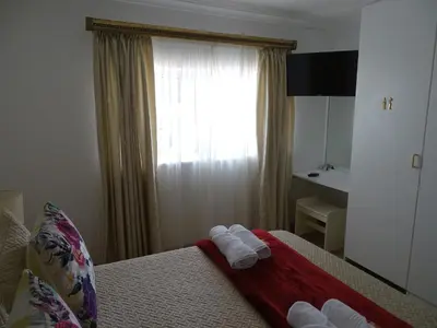 a hotel room with a bed with towels on it at Big Skies Guesthouse in Gordonʼs Bay