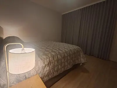 a bedroom with a bed with a lamp next to it at Salt & Sandy Shores Dolphin Beach Blouberg in Cape Town