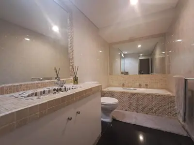a bathroom with a sink and a tub and a toilet at Salt & Sandy Shores Dolphin Beach Blouberg in Cape Town