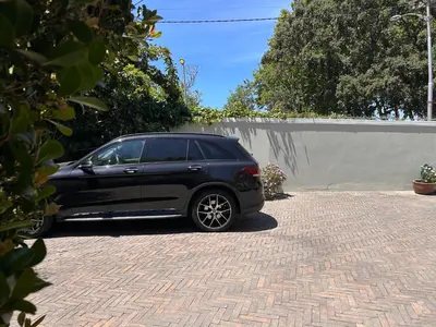 a black car parked in a driveway at Bishopsfield Guesthouse Rondebosch in Cape Town