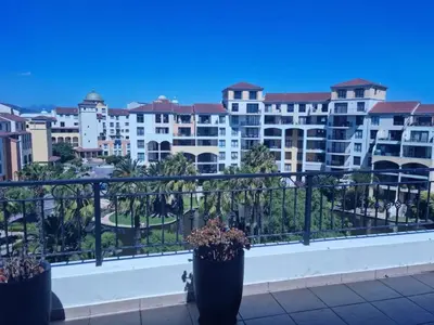a balcony with two potted plants and buildings at Nice Views in Cape Town
