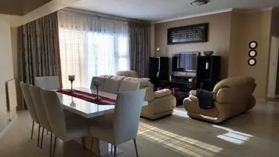a living room with a table and chairs and a couch at Nice Views in Cape Town