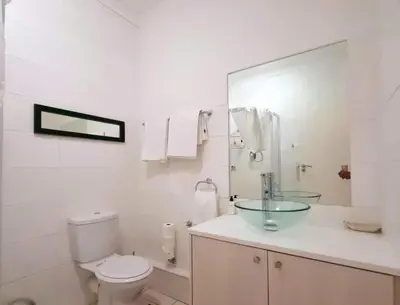 a white bathroom with a toilet and a sink at Nice Views in Cape Town