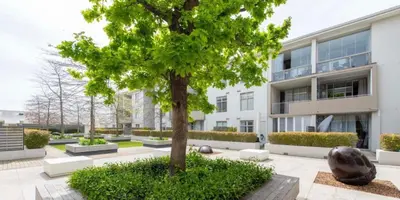 a large building with a tree in front of it at Andringa Walk, Modern 2 Bedroom Apartment in Stellenbosch