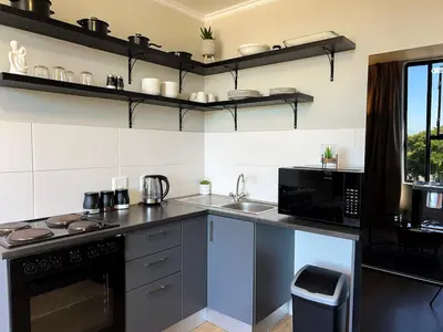a kitchen with a counter and a sink and a stove at The Hideaway on Moringa Way in Cape Town
