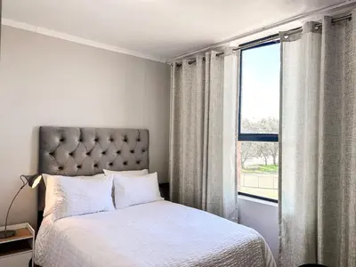 a bedroom with a bed and a large window at The Hideaway on Moringa Way in Cape Town