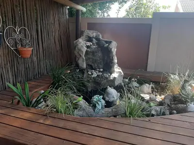 a garden with a rock and plants on a wooden deck at Simply The Choice Manor in Cape Town