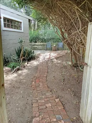 a brick walkway leading into a yard with a tree at Groendraai PetFriendly SelfCatering Accommodation, Die Karoohuis, Die Wijnhuis and Die Vinknes