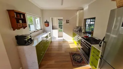 a kitchen with green cabinets and a stove top oven at Tranquil Stylish Home with Nature Pool near Reserve in Somerset West