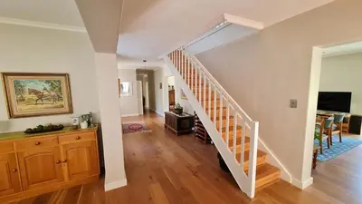 a white staircase in a living room with a dining room at Tranquil Stylish Home with Nature Pool near Reserve in Somerset West