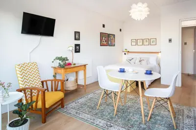a living room with a table and chairs and a bed at House Indlovu in Hermanus