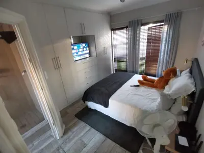 a teddy bear sitting on a bed in a bedroom at Cosy 3 bedroom in Cape Town