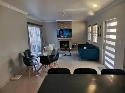 a living room with a table and chairs and a couch at Cosy 3 bedroom in Cape Town